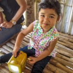 Young girl playing with a yellow solar lantern in Philippines, SEF project