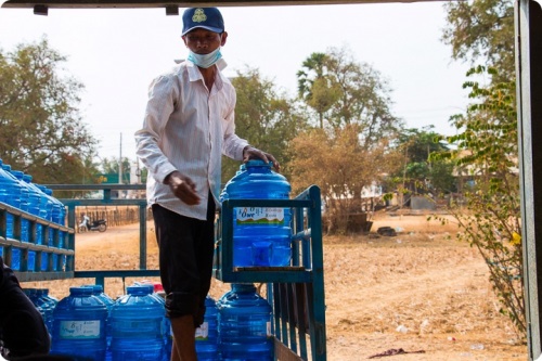 Cambodgien transportant des bouteilles de 20L d'eau