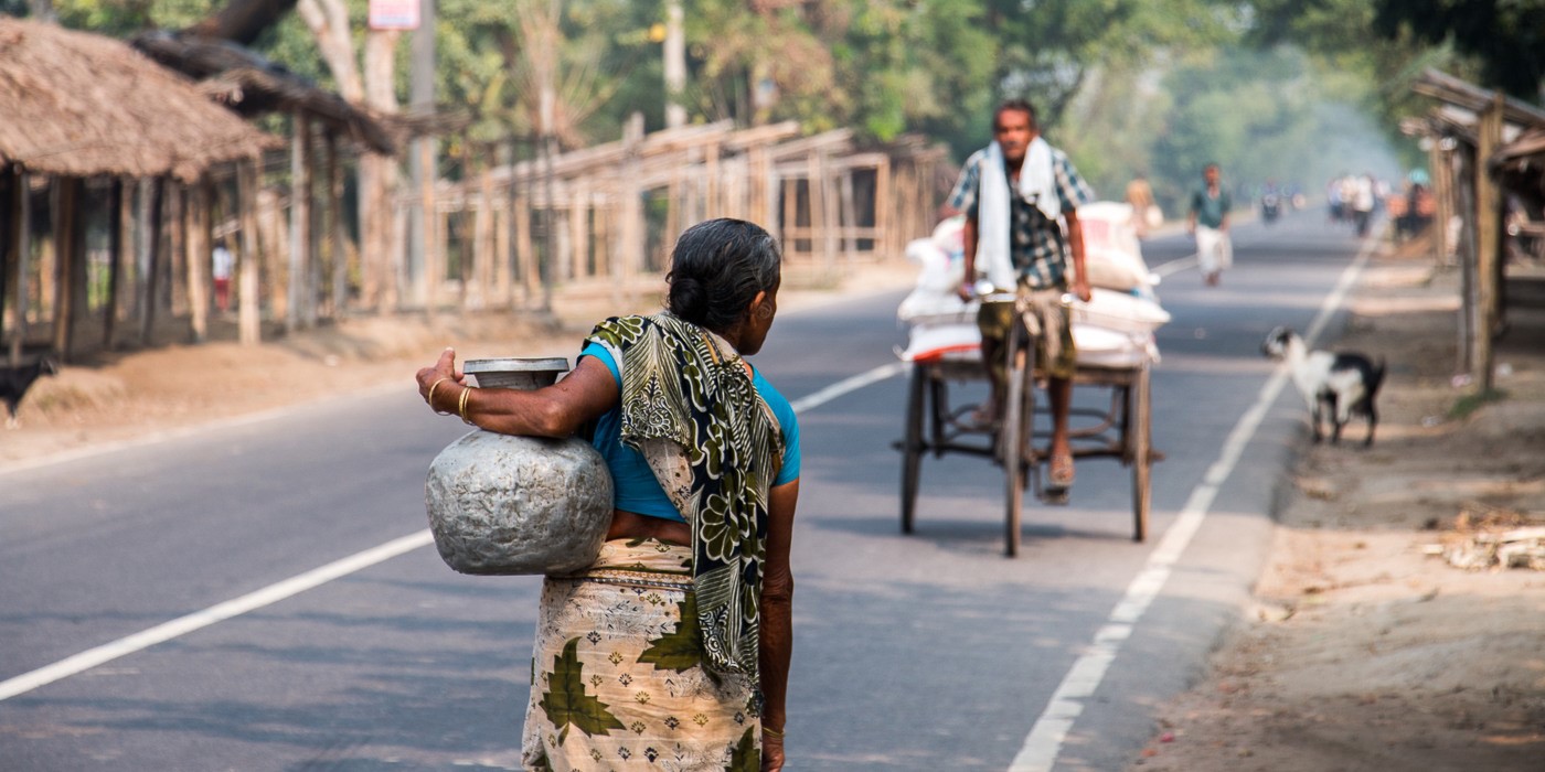 Women Carrying Water In A Jar, Walking On A Street In Cambodia